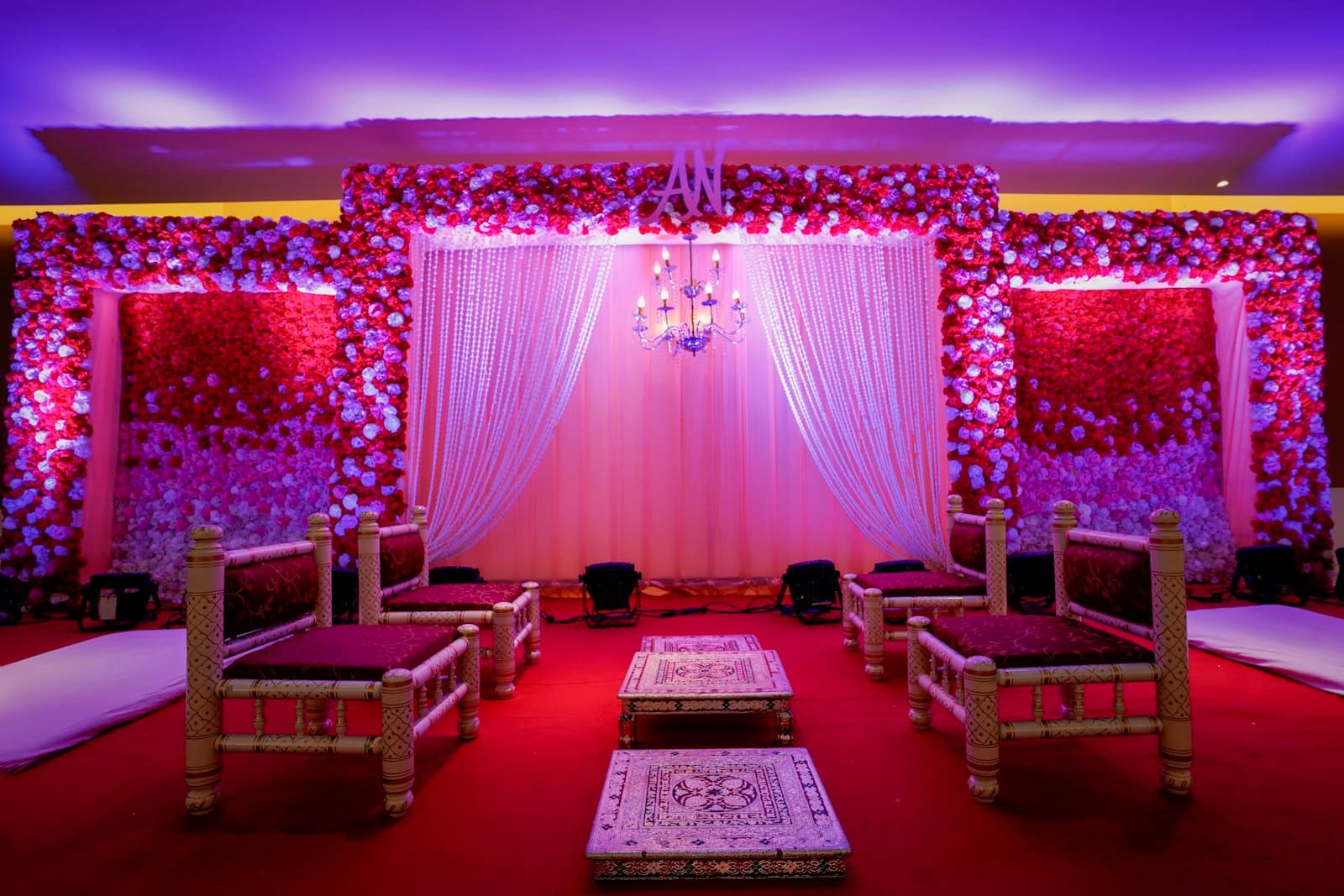 Red and green seating laid out inside a decorated wedding venue.